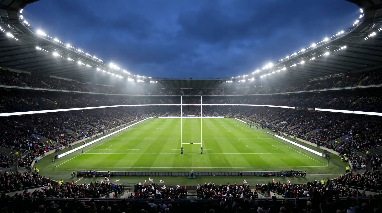 Rugby knockout match under floodlights at a Rugby World Cup 2027 venue in the evening